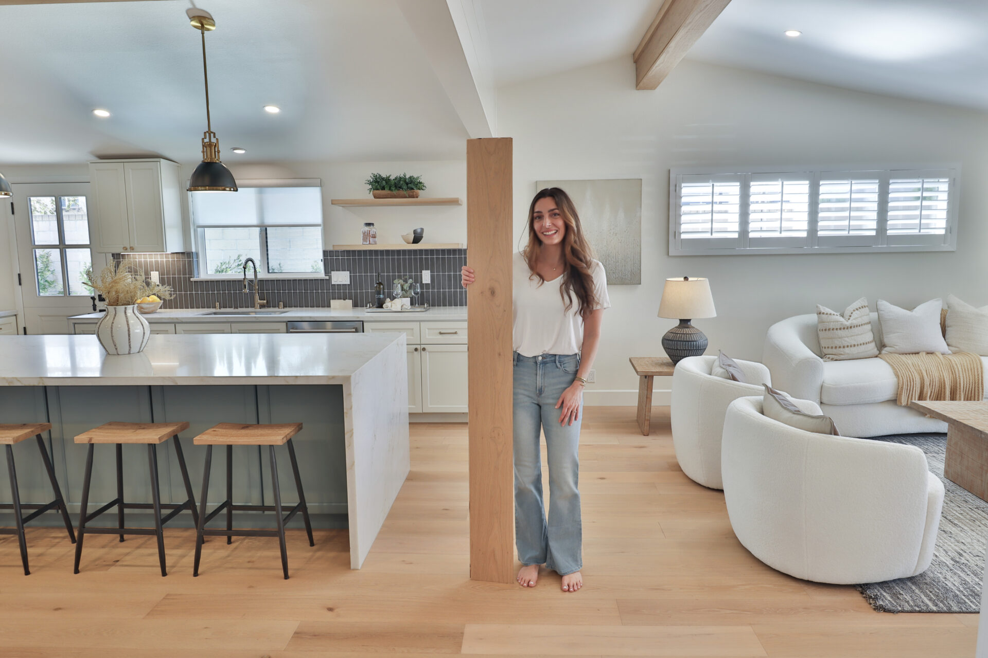 Woman holding a flooring plank in CALI Floors showroom kitchen.